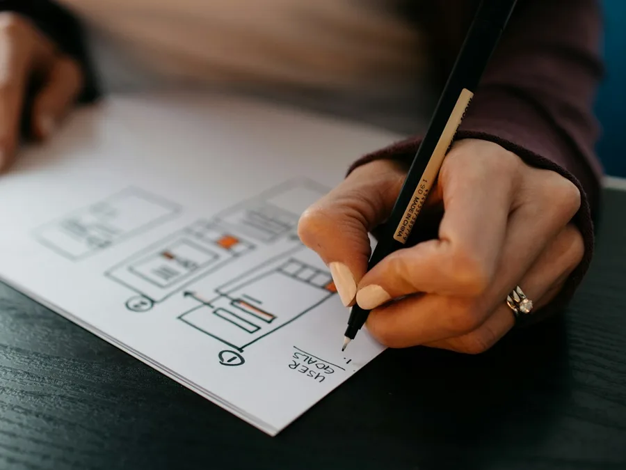Hand sketching a website wireframe on paper